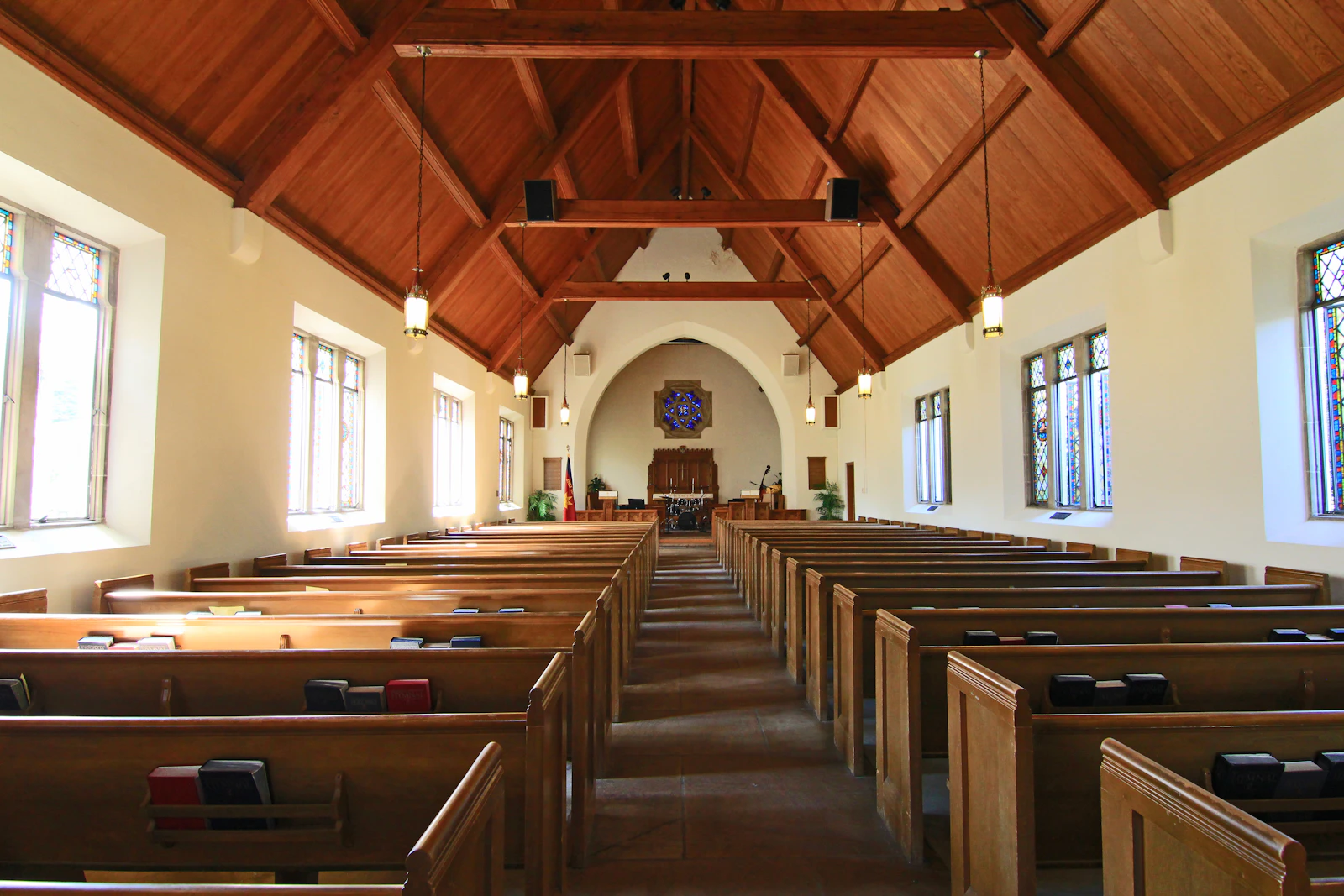 Sunlit sanctuary with wooden pews before a Sunday service